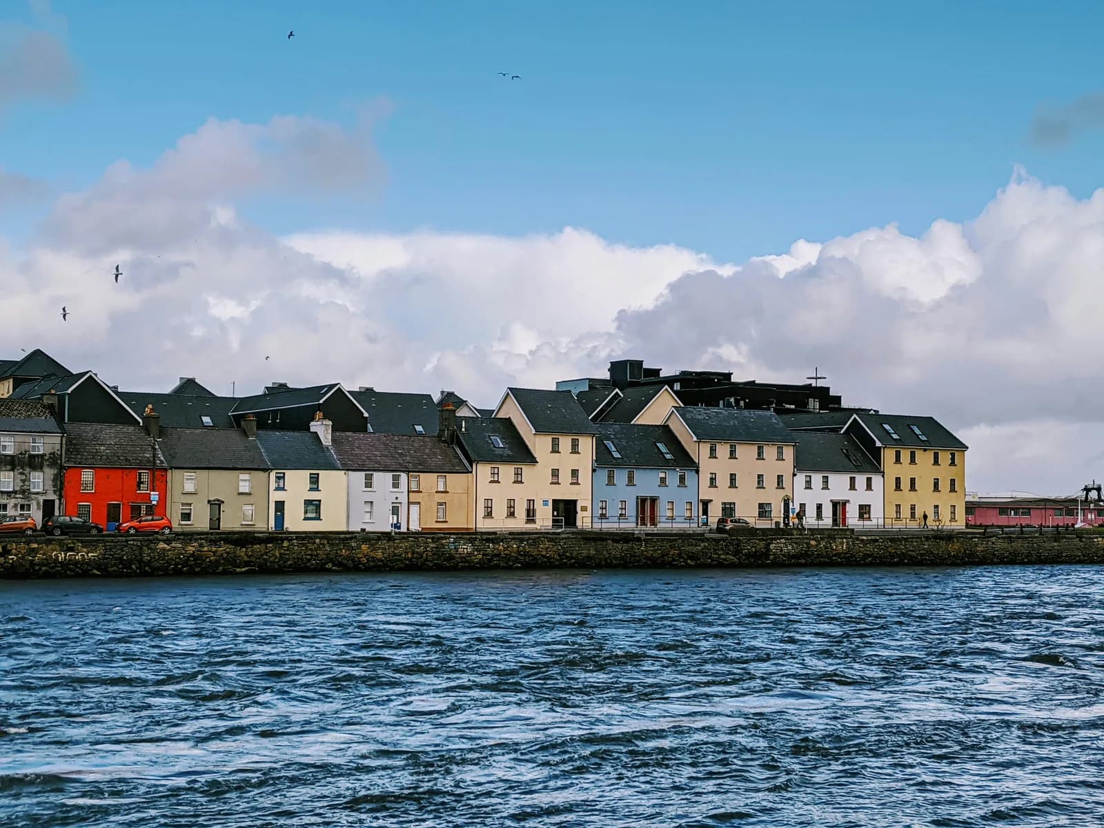 The colourful terraced houses of the Long Walk at the mouth of the River Corrib in Galway.